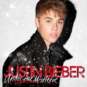 Under The Mistletoe Primeiro album natalino, casaco preto, fundo claro e fonte na cor vermelha.